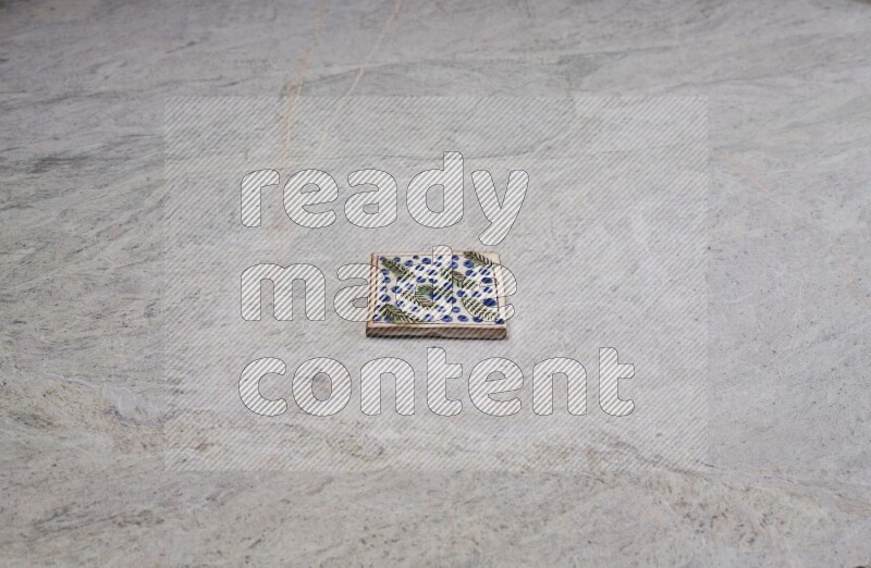 Top view shot of a pottery coaster\ tile on beige marble flooring