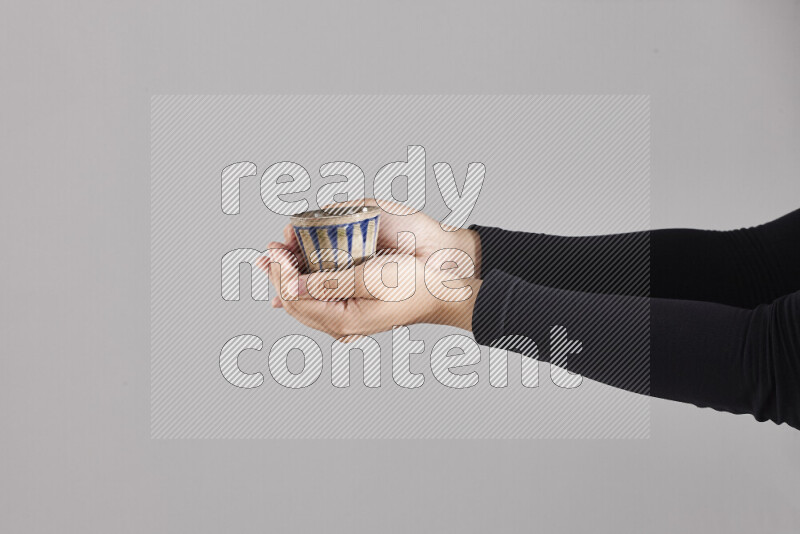 امرأة ترتدي عباءة سوداء تحمل أدوات فخارية مختلفة في أوضاع متعددة