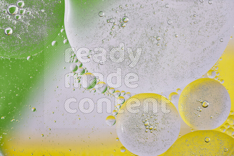 لقطات مقربة لفقاعات من الزيت على سطح الماء باللون الأصفر والأخضر والأبيض