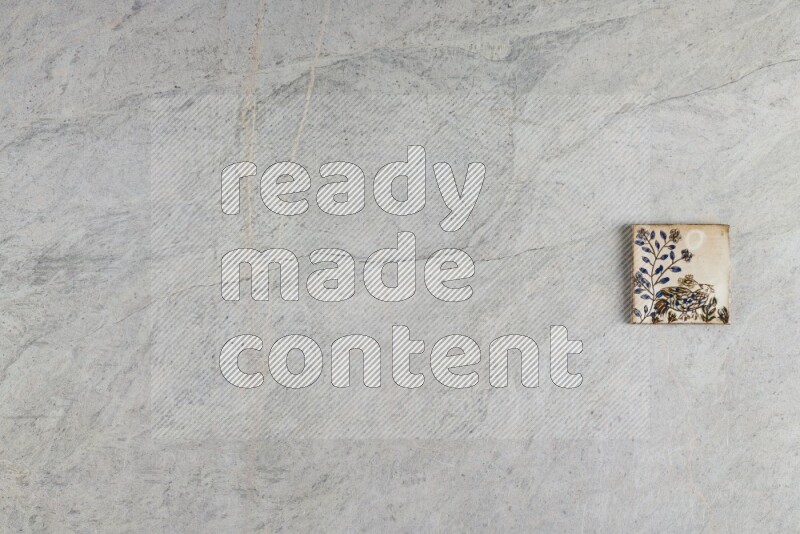 A decorative pottery coaster on grey marble background
