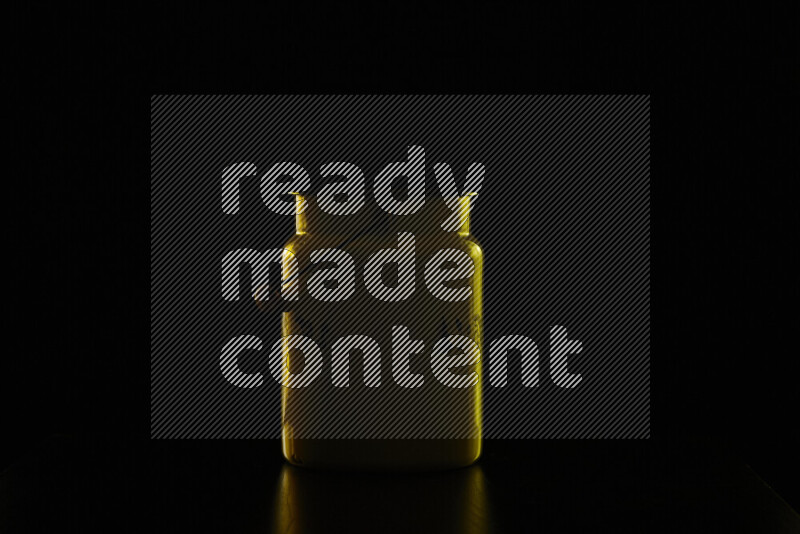 A vintage milk canister with colored rim light against black background