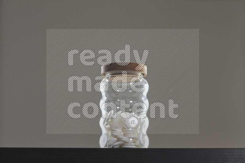 Buttons in a glass jar on black background