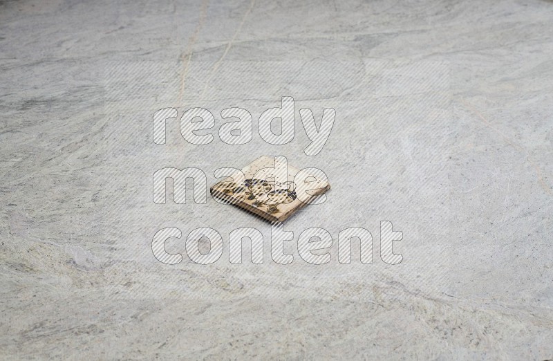 Top view shot of a pottery coaster\ tile on beige marble flooring