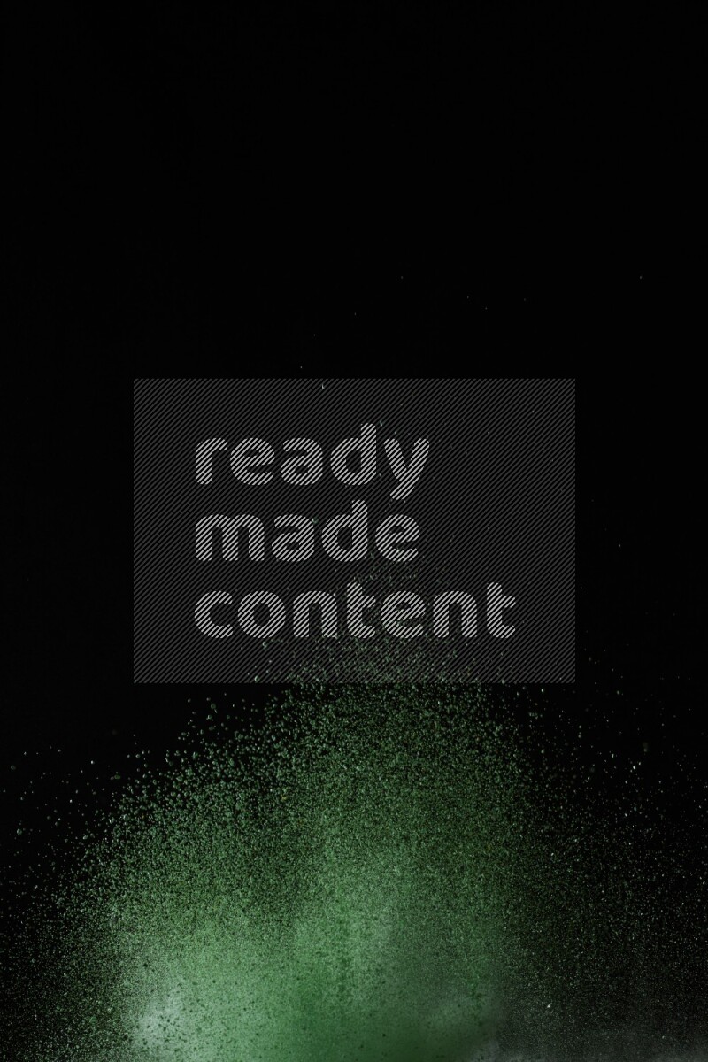A side view of green powder explosion on black background