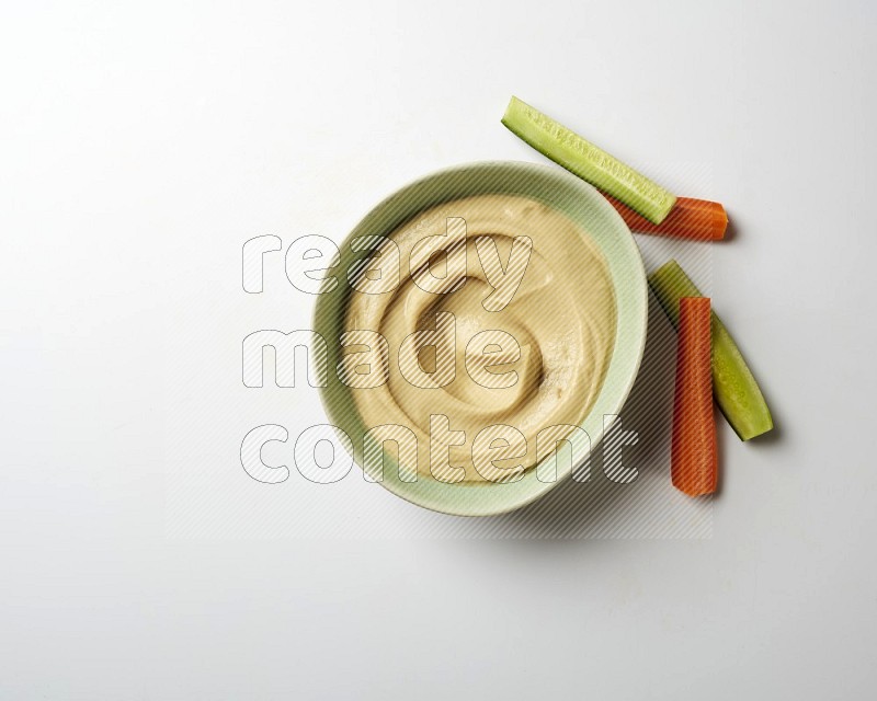 plain Hummus in a green plate on a white background
