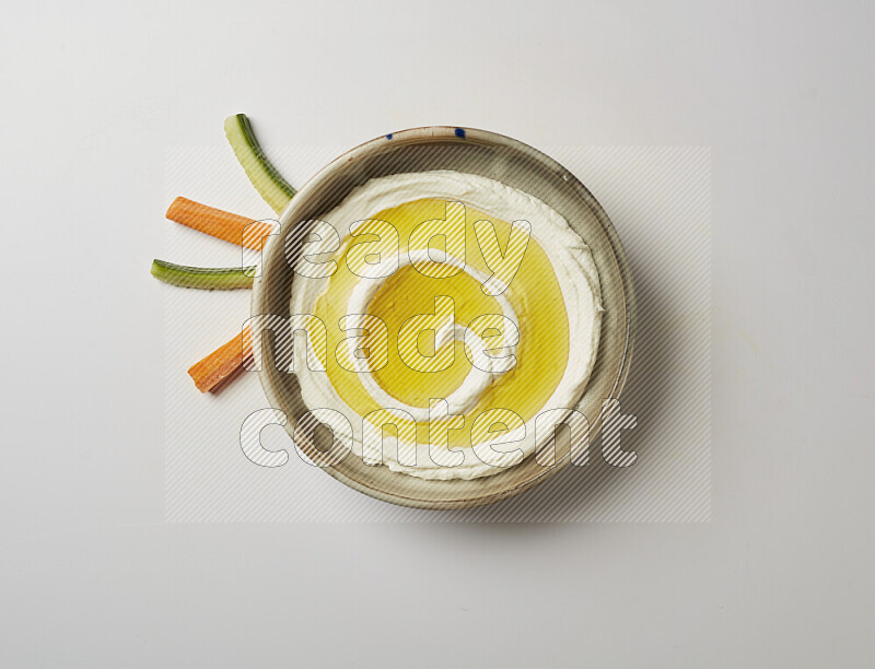 Lebnah garnished with olive oil in a grey pottery plate on a white background