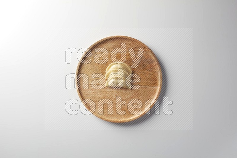 Three Sambosas on a wooden round plate on a white background