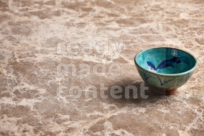 A decorative pottery bowl on beige marble background