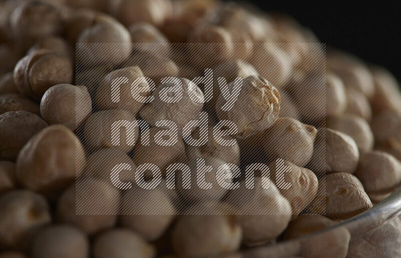 Chickpeas in a glass jar on black background