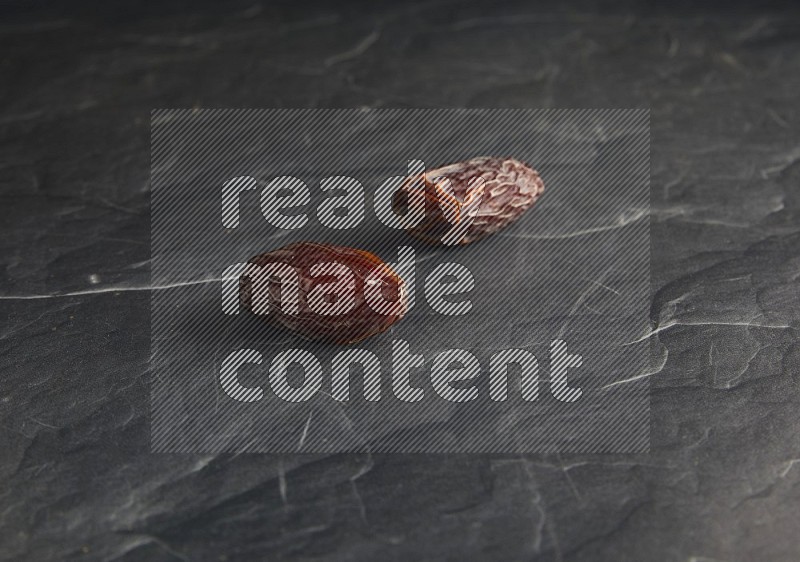 two madjoul dates on a black textured background