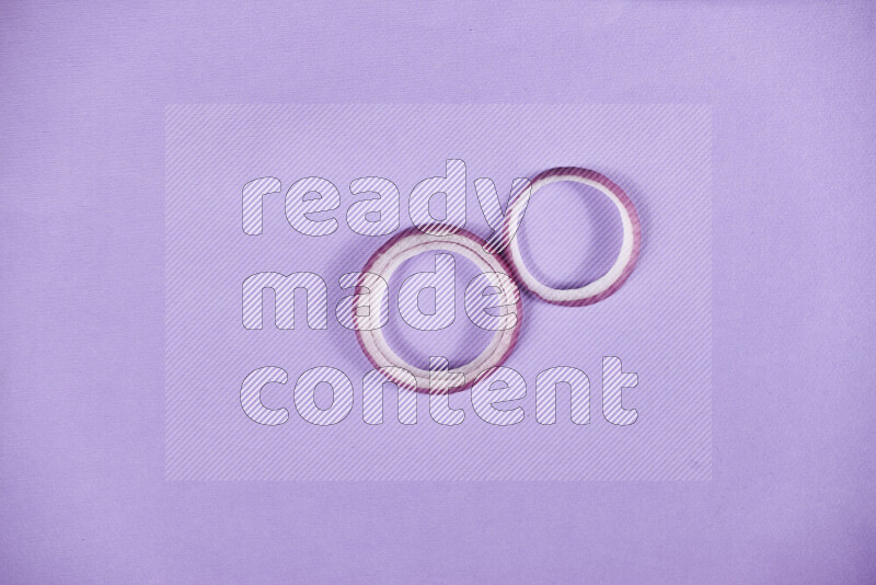 Red onions rings on purple background