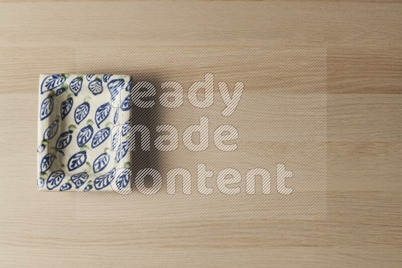 A decorative pottery plate on light wooden background