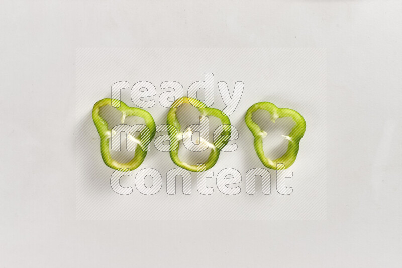 Green bell pepper slices on white background