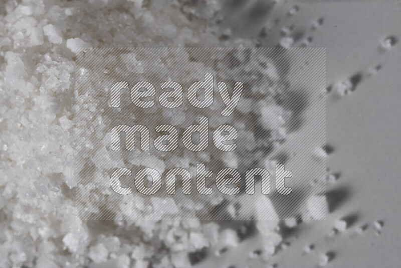 A bunch of coarse sea salt crystals on white background