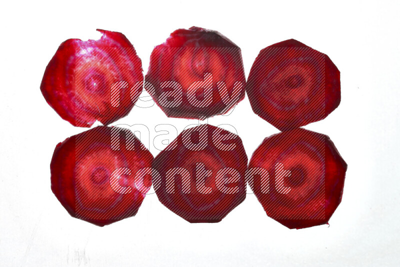 Beet slices on illuminated white background