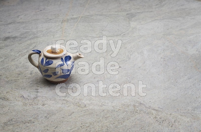 A Pottery Teapot On Grey Marble Flooring