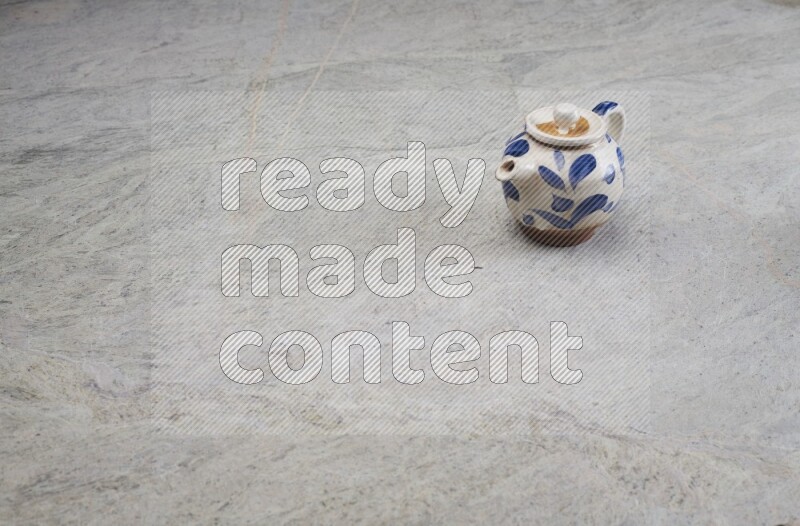 A pottery teapot on grey marble background