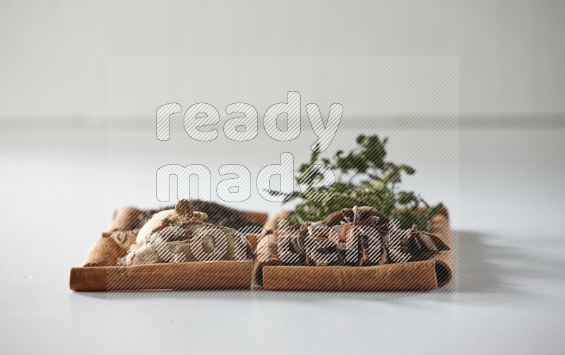 4 squares of cinnamon sticks full of tea, mint, star anise and ginger on white flooring