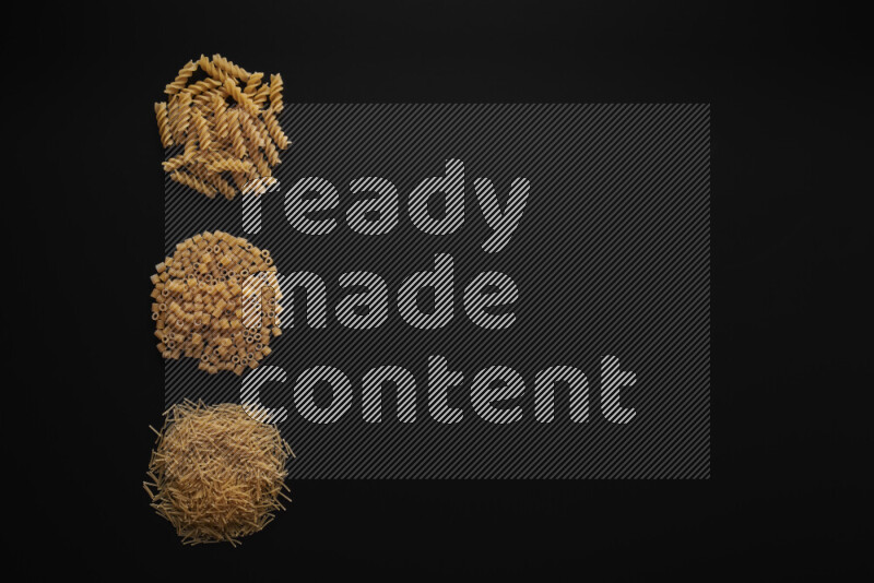 Different pasta types in 3 bunches on black background