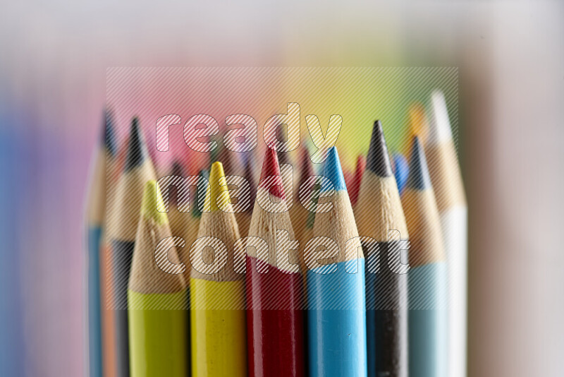 The image captures a close-up of sharpened colored pencils on multicolored background