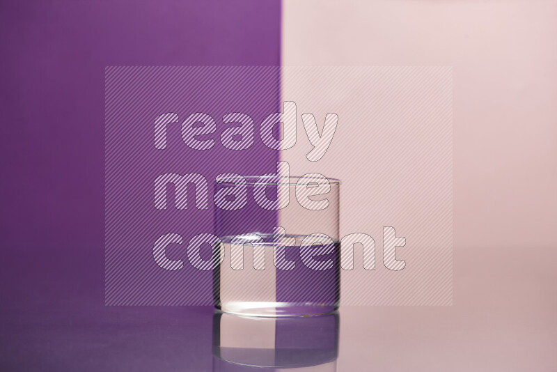 The image features a clear glassware filled with water, set against purple and rose background