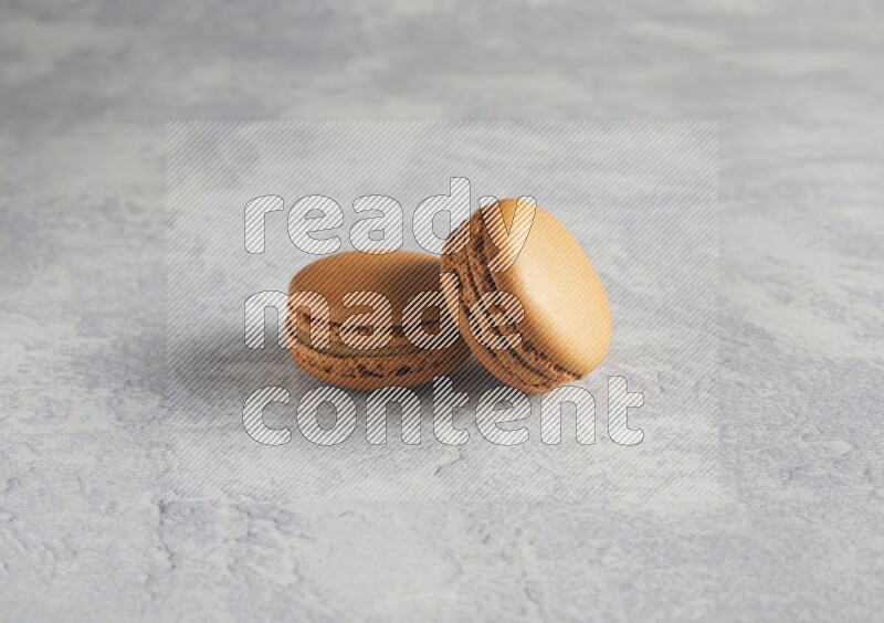 45º Shot of two Brown Maple Taffy macarons  on white  marble background