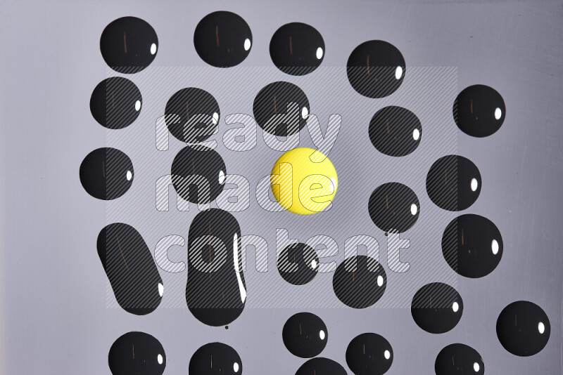 Close-ups of abstract yellow and black paint droplets on the surface