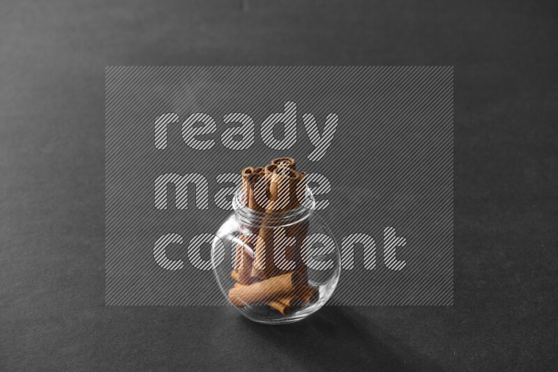 أعواد القرفة في وعاء زجاجي علي خلفية سوداء