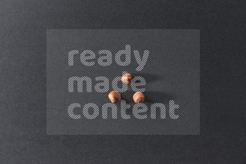 3 hazelnuts on a black background in different angles