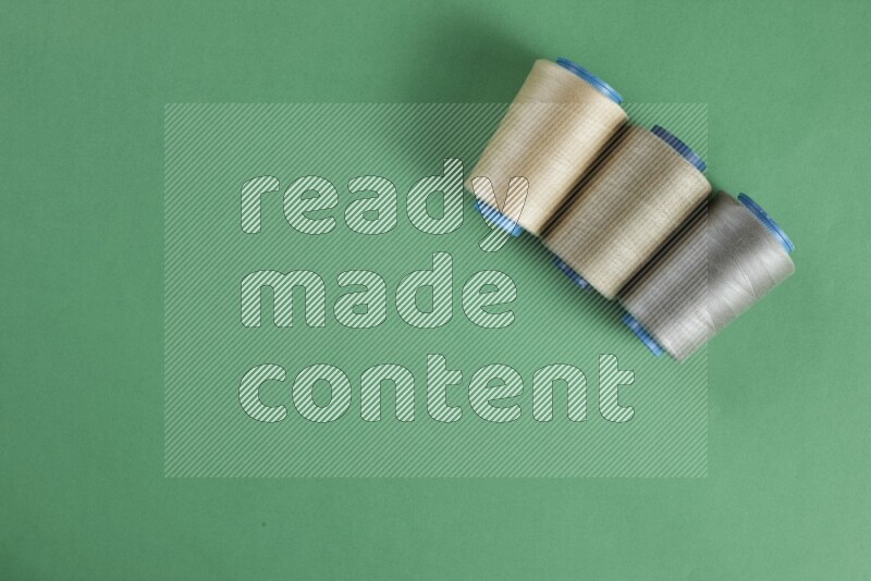 A brown collection of sewing and tailoring tools arranged on a green background