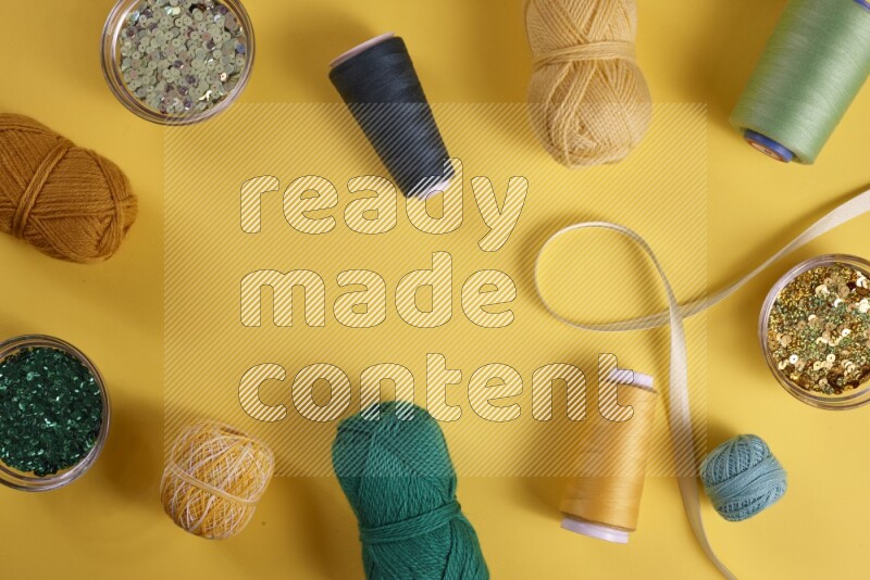 مجموعة من أدوات الخياطة والتفصيل خضراء اللون على خلفية صفراء