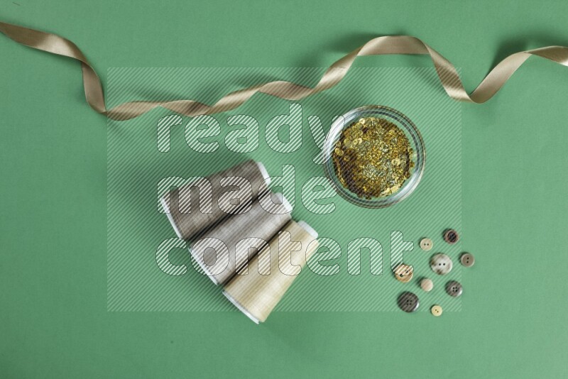 A brown collection of sewing and tailoring tools arranged on a green background