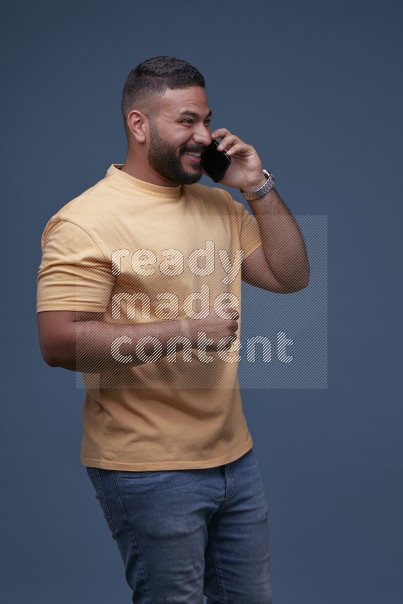 A man Calling on Blue Background wearing Orange T-shirt
