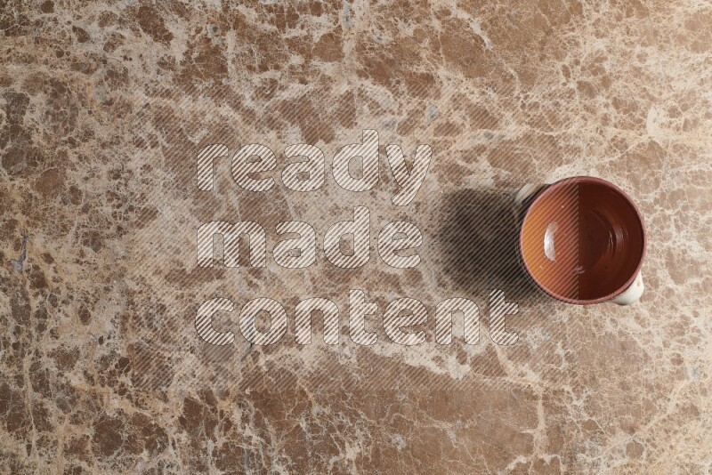 A multicolored pottery pot on beige marble background