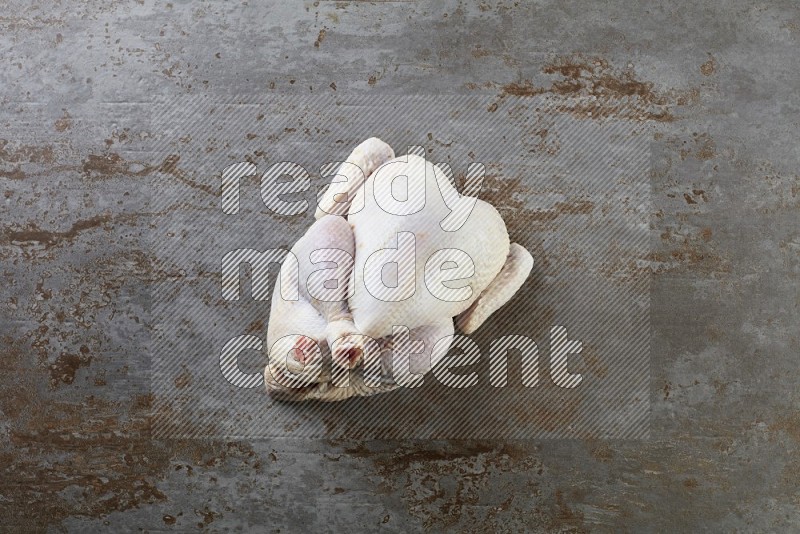 whole raw chicken  direct on a rustic grey background