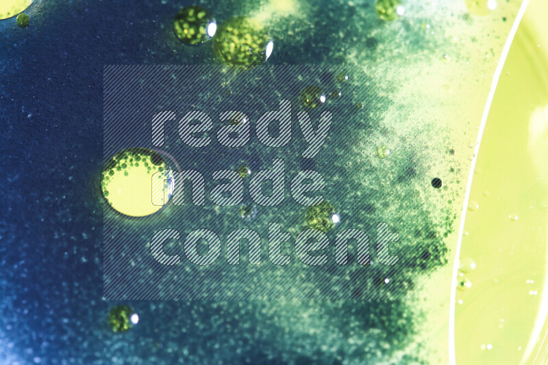 Close-ups of abstract yellow, blue and green watercolor drops on oil Surface on white background