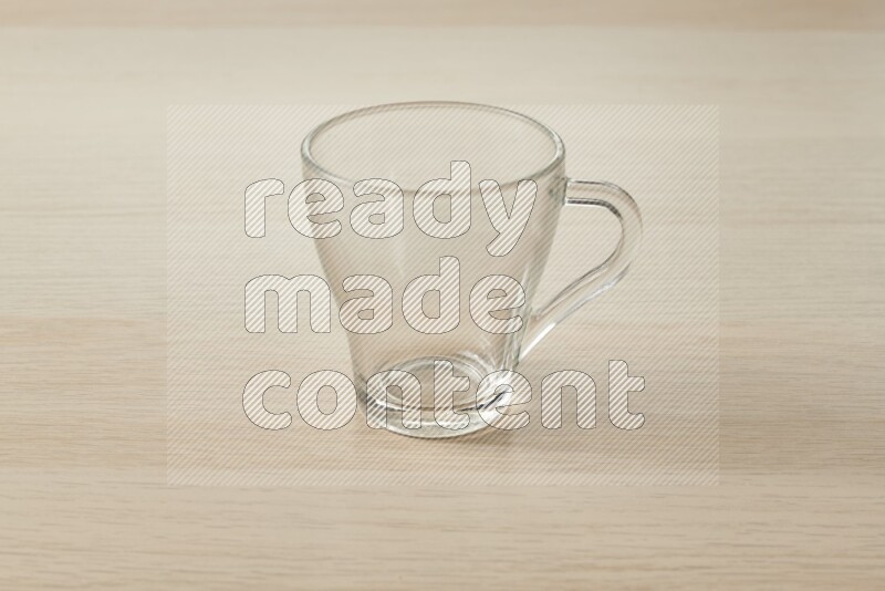 An empty glass cup on light wooden background