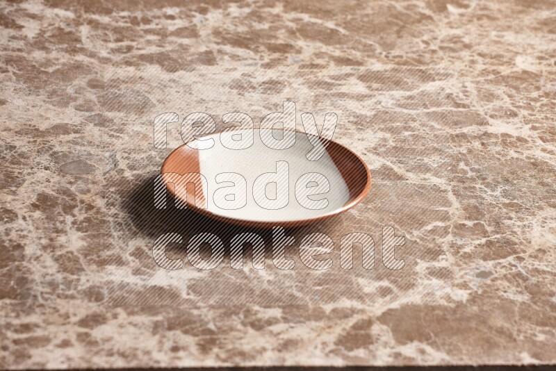A multicolored pottery plate on beige marble background