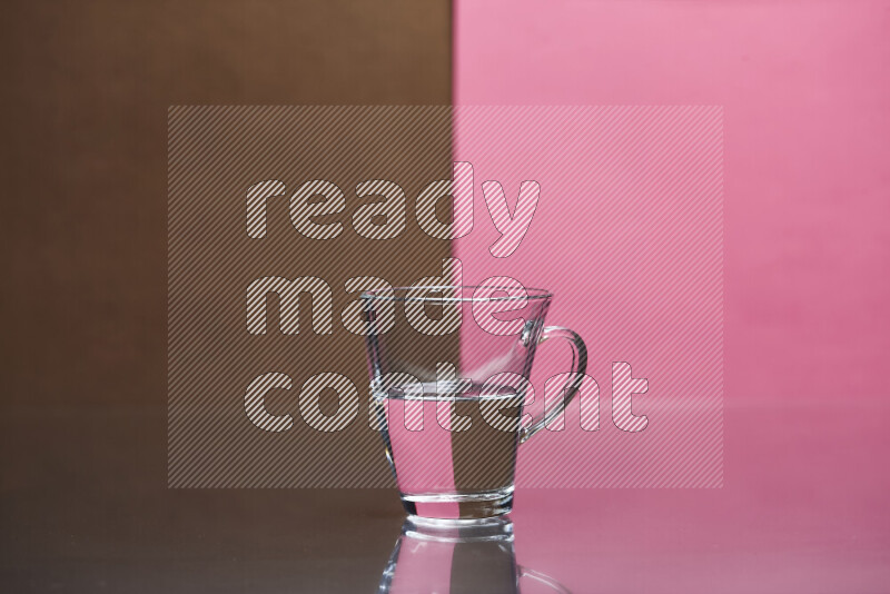 The image features a clear glassware filled with water, set against brown and pink background