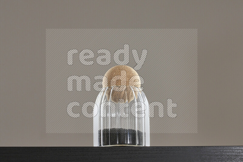 حبة البركة في وعاء زجاجي على خلفية سوداء