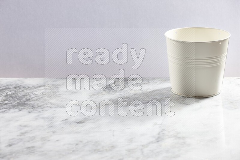 An empty white plant pot on grey marble background