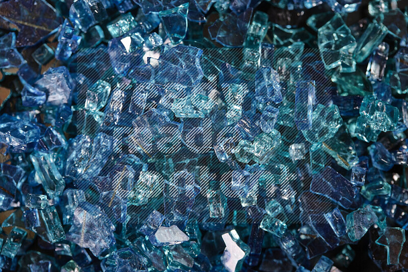 قطع زجاج زرقاء شفافة متناثرة على خلفية سوداء