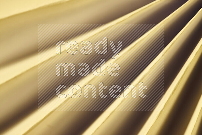 An image presenting an abstract paper pattern of lines in gold tones