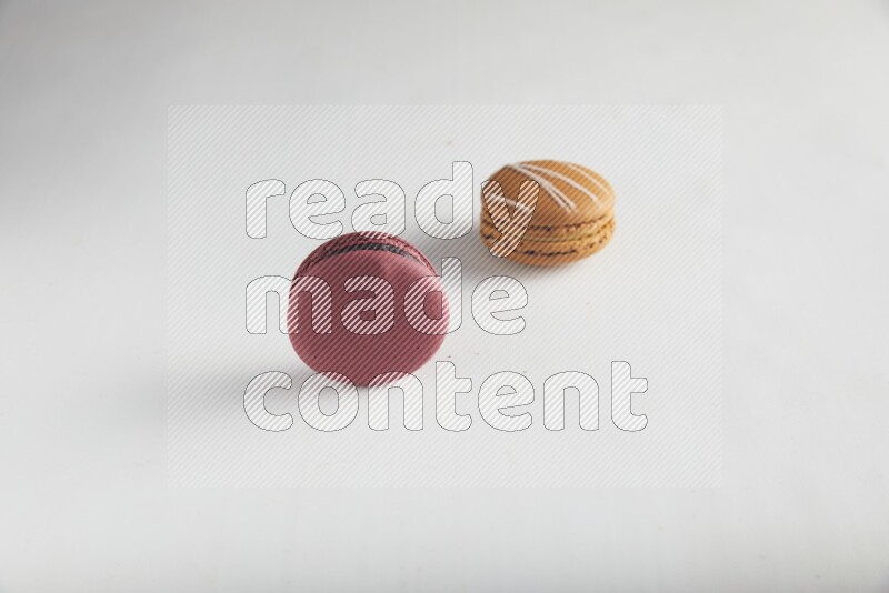 45º Shot of of two assorted Brown Irish Cream, and Red Cherry macarons on white background