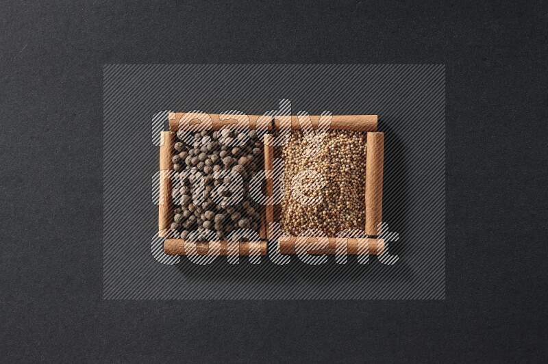 2 squares of cinnamon sticks full of mustard seeds and allspice on black flooring