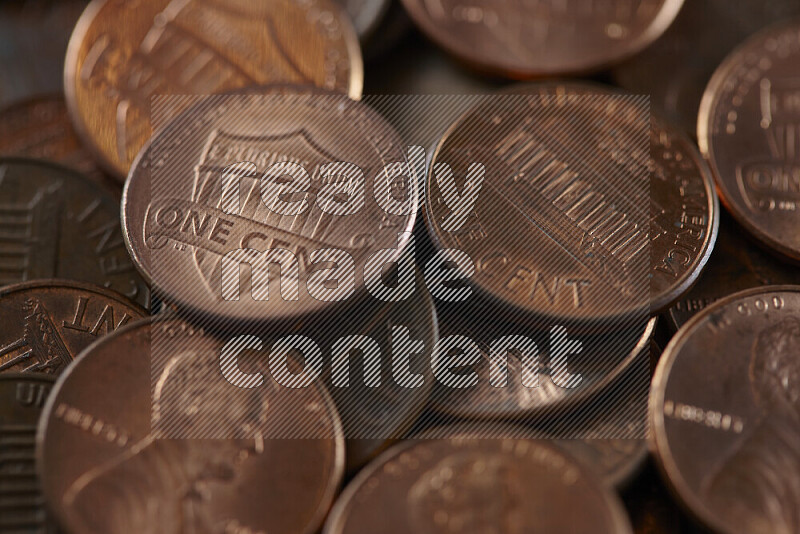 A close-up of scattered United States one cent coins on grey background