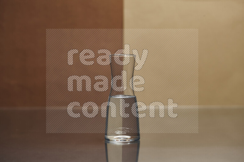 The image features a clear glassware filled with water, set against brown and light brown background