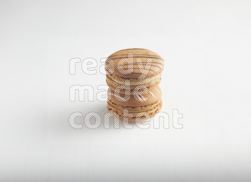 45º Shot of of two assorted Brown Irish Cream, and light brown  Almond Cream macarons on white background