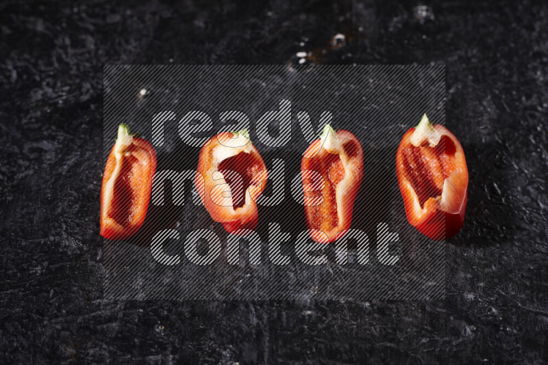 Red bell pepper slices on black background