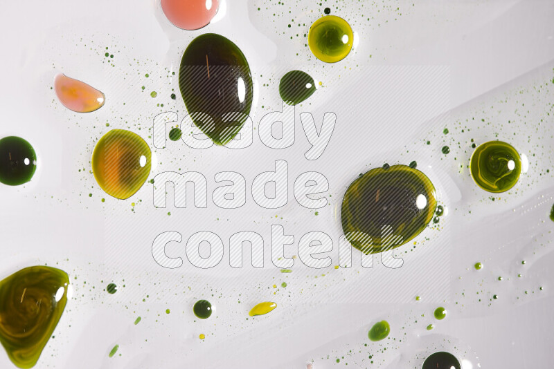 Close-ups of abstract green, yellow and red paint droplets on the surface